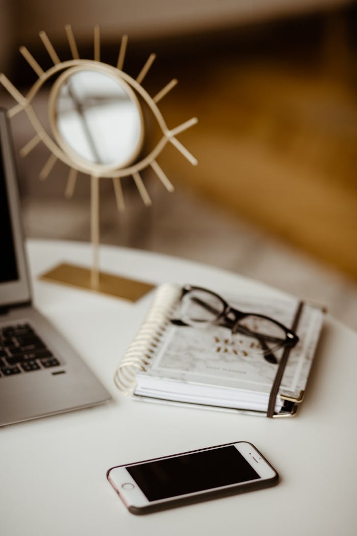 brand-01 Stylish home office with a laptop, planner, glasses, and phone on a cozy desk.
